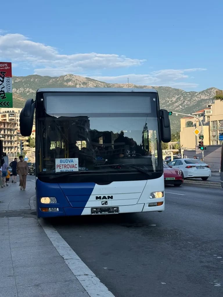 A full-size Mediteran Express bus in Budva with a white BUDVA–PETROVAC route card in the windscreen.